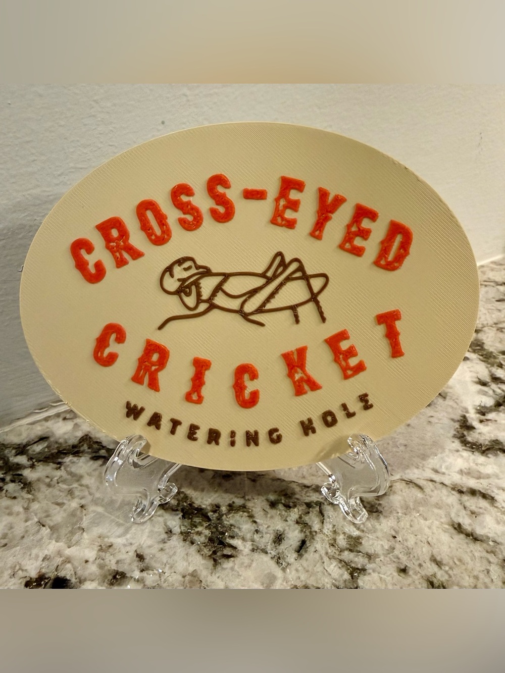 Cross-Eyed Cricket Watering Hole Retro Oval Sign Plaque Cream Red & Brown NEW